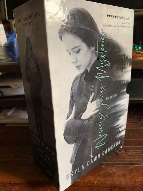 Boxset for Waverly Jones mysteries vol 1 with a dark haired woman hugging herself with her head bowed.